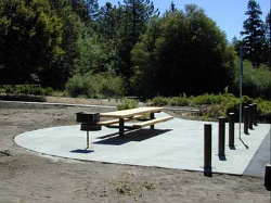 Vista general de un merendero con pavimento duro y mesa y barbacoa accesibles