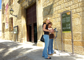 Dos personas leyendo información de un edificio junto a un cartel informativo accesible