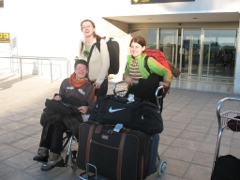 Asistente personal ayudando a una persona en silla de ruedas en su llegada al aeropuerto