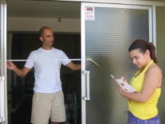 Dos personas midiendo el ancho libre de paso de una puerta de acceso