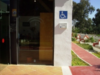 Suelo destacado cromáticamente y con textura diferente para su fácil percepción. Señal de accesibilidad en la entada del edificio